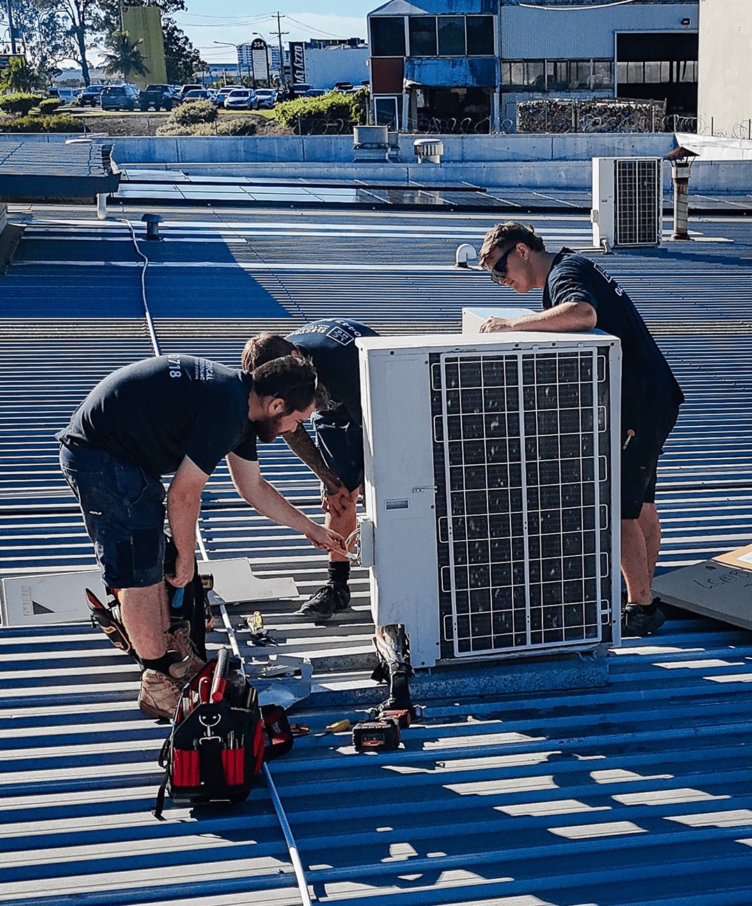 LCMB electricians installing a rooftop air conditioning condenser unit
